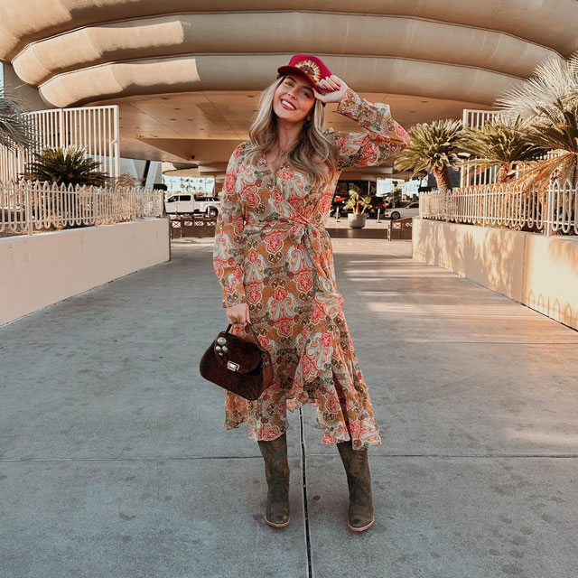 A woman wearing Justin Western Boots and a Justin Dress.